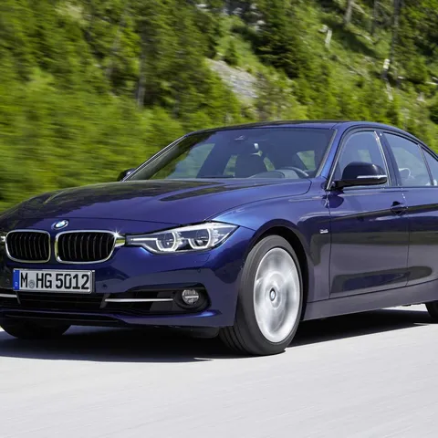 Dark blue BMW F30 3 Series saloon driving, front three-quarter view